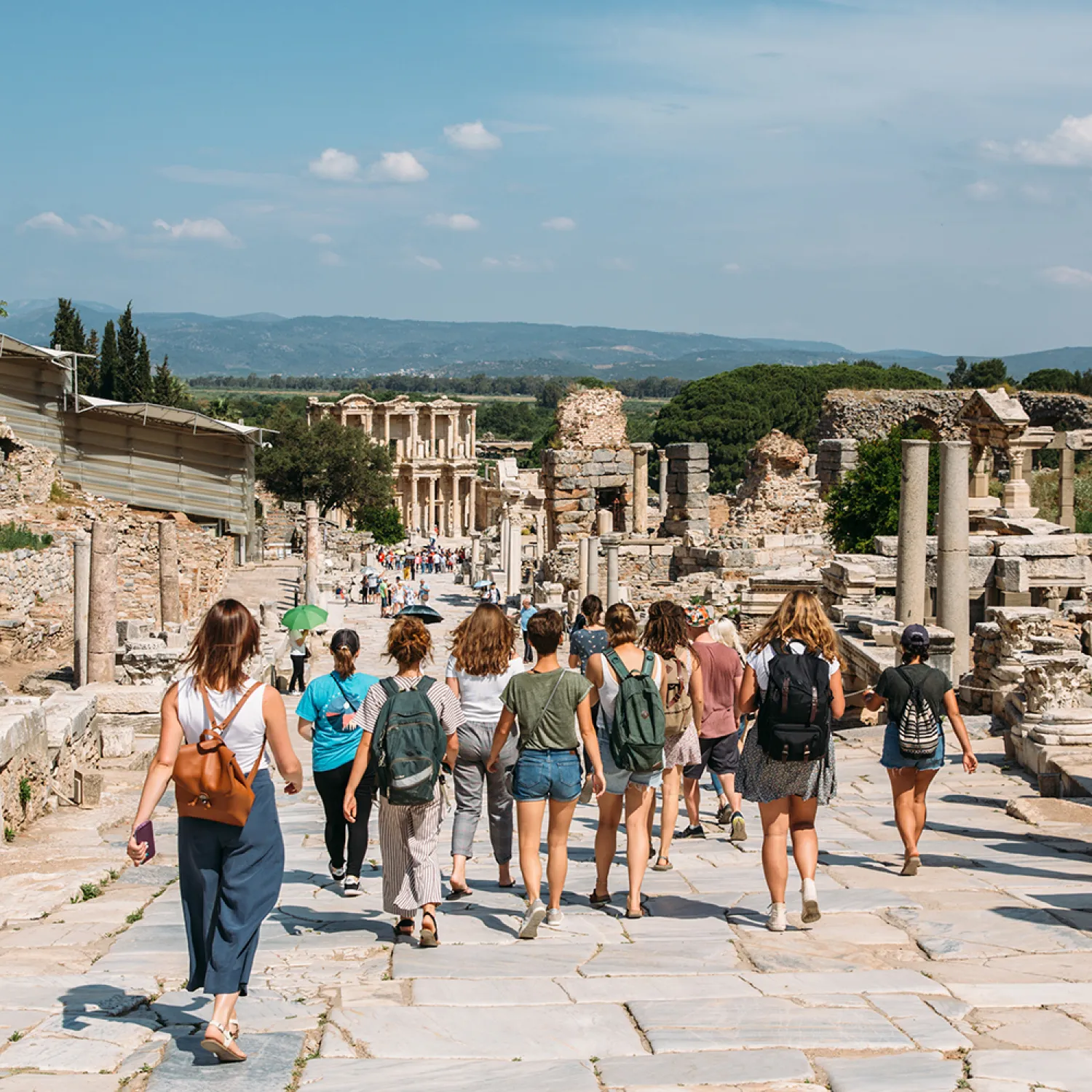 A small crowd of outreach students walking in an ancient stoned city.