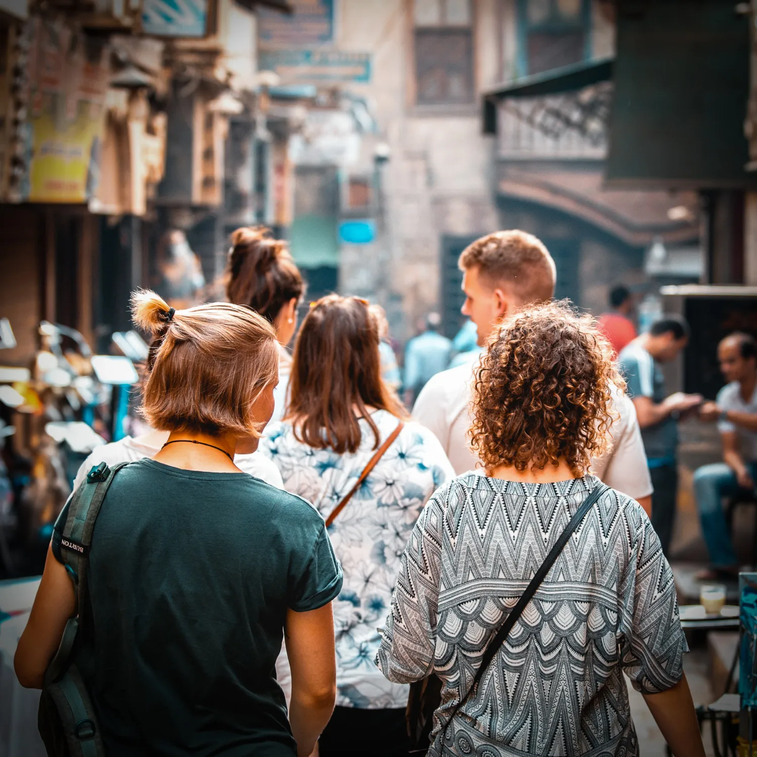 An image of a group of students walking through a road in a city.
