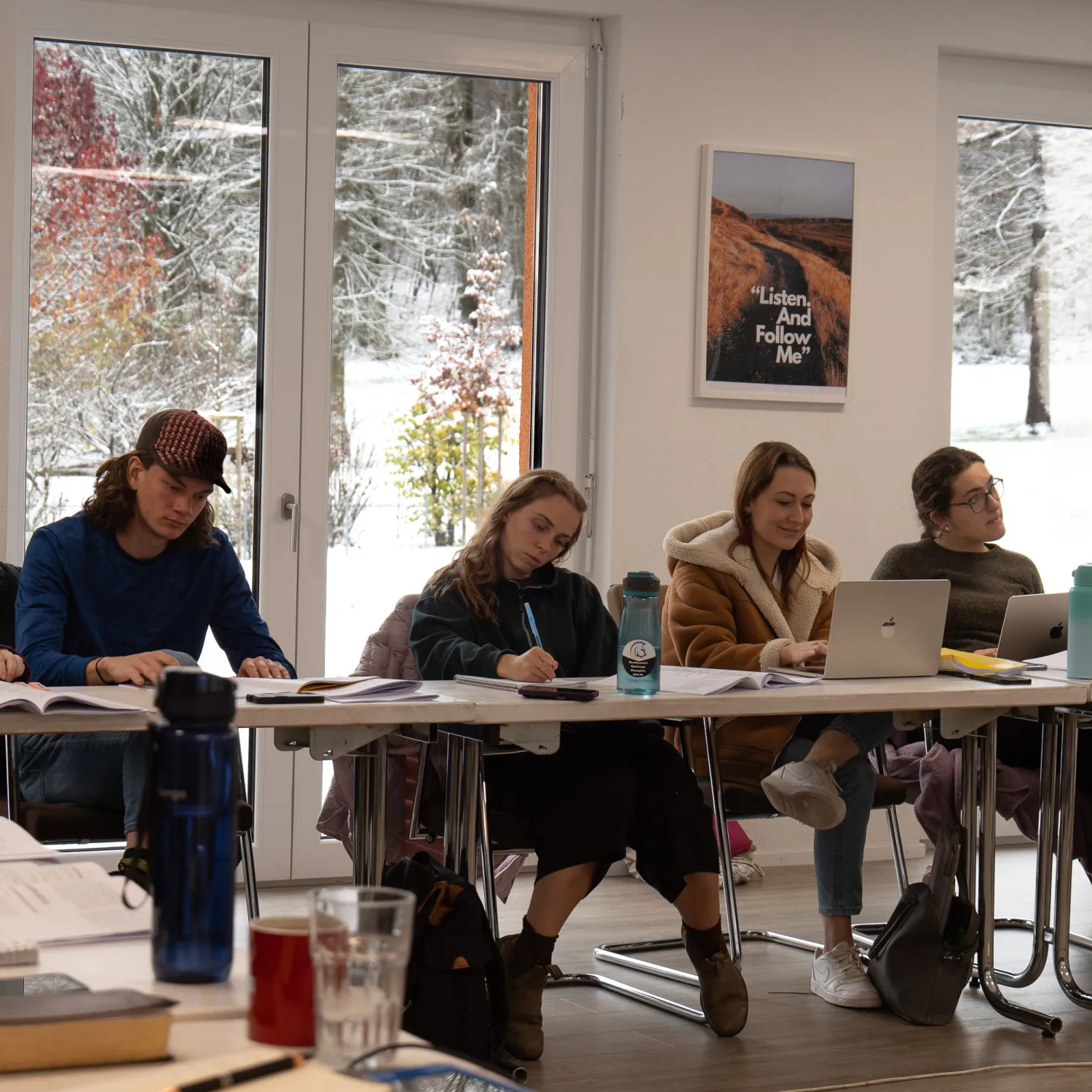 A group of students seated in a classroom taking notes.